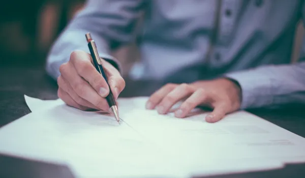 Mano che firma un documento